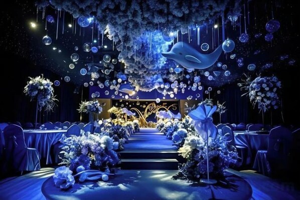A formal event space with a central stage, rows of tables, and floral arrangements. - ShangHai NvYan Hotel (Shanghai)
