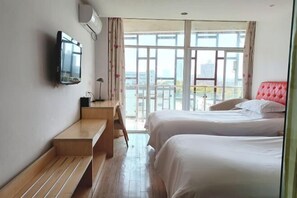 A hotel room with two beds, a TV mounted on the wall, a wooden bench, and a balcony with a view of the city. - ShangHai NvYan Hotel (Shanghai)