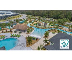 Un complexe hôtelier doté d’une piscine centrale, d’espaces de détente et d’une structure à toit de chaume.