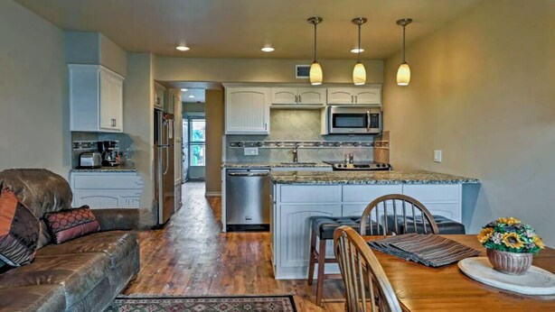 A modern kitchen with white cabinets, a central island, and pendant lighting. - Updated Comal River Condo, 2 bedroom,2 bath, 1 mi to Schlitterbahn (New Braunfels)