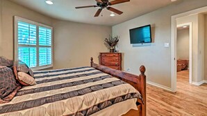 A bedroom with a bed, a ceiling fan, a TV mounted on the wall, and a dresser. - Updated Comal River Condo, 2 bedroom,2 bath, 1 mi to Schlitterbahn (New Braunfels)