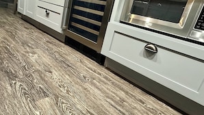 A kitchen with white cabinetry, a stainless steel oven, and a wood-patterned floor. - Experience the Ultimate Getaway at Our Stunning Riverfront Property!!! (St. Joseph)