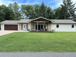 A two-story house with a covered porch, a garage, and a well-maintained lawn.
