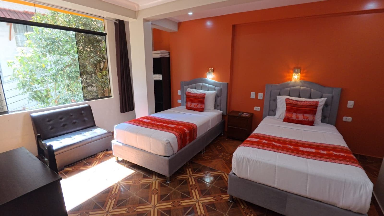 Una habitación de hotel con dos camas, un sofá y una mesita.