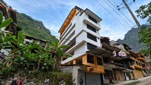 Un edificio de varios pisos con techo plano y un balcón en el segundo piso.