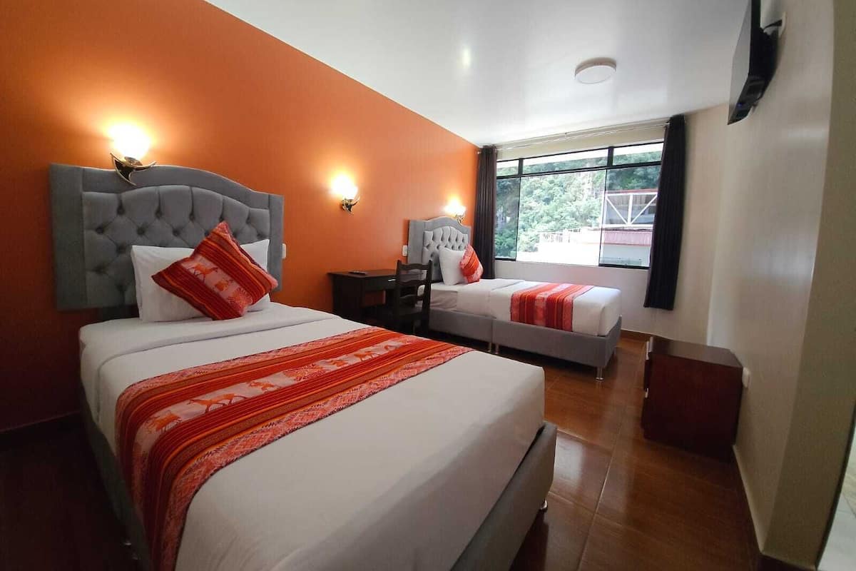 Une chambre d’hôtel avec deux lits, une grande fenêtre et une vue sur l’extérieur.