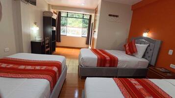 Habitación de hotel con dos camas, un armario, un espejo, una ventana con vistas y un aplique de pared.