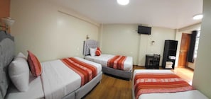 A hotel room with three beds, a TV, a desk, and a wardrobe. - Hotel Horizonte (Machu Picchu)
