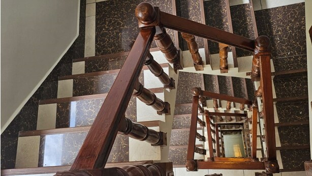 A wooden staircase with a geometric patterned floor. - Hotel Horizonte (Machu Picchu)