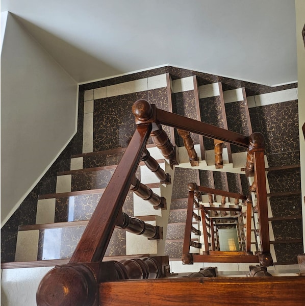 A wooden staircase with a geometric patterned floor. - Hotel Horizonte (Machu Picchu)