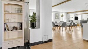 A spacious kitchen with a dining area, wooden flooring, and modern appliances.