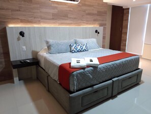 A modern bedroom with a bed, nightstands, and a red blanket.