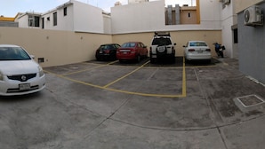 A parking area with several cars, including a white sedan, a red car, and a white SUV. - EXECUTIROOMS Veracruz (Veracruz)