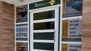 A hotel entrance with a signboard advertising room sizes, amenities, and contact information. - EXECUTIROOMS Veracruz (Veracruz)
