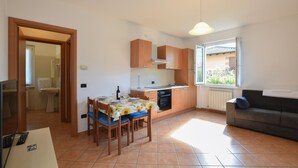 Un espace de vie compact comprenant un coin repas, une kitchenette et un canapé.