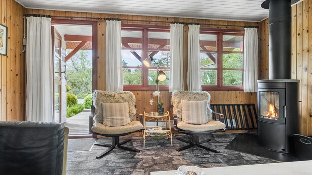 A cozy room with two chairs, a table, and a wood-burning stove. - 2 bedroom beautiful home in Toftlund (Toftlund)