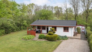 A single-story white house with a dark roof, a porch with a wooden bench, and a small shed. - 2 bedroom beautiful home in Toftlund (Toftlund)