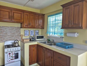 Een microgolfoven, een oven, een kookplaat, kookgerei, borden en bestek