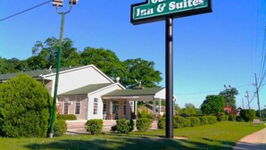 Une enseigne pour le Garden Inn & Suites, avec un espace extérieur aménagé et abrité, ainsi qu’une pelouse bien entretenue.