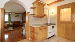 A compact kitchen with wooden cabinets, a built-in oven, and a tiled backsplash.