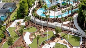 Un parcours de golf comportant plusieurs trous, agrémenté d’un élément aquatique central et d’un aménagement paysager environnant.
