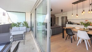 A modern apartment with a balcony, a dining area, and a kitchen.