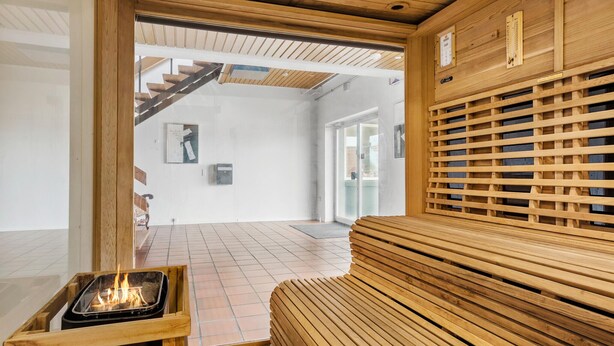 A wooden interior with a fireplace, a bench, and a staircase leading to an upper level. - 11 bedroom gorgeous home in Hurup Thy (Hurup Thy)