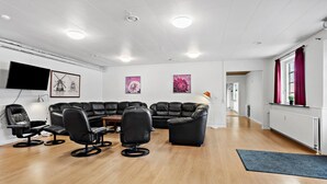 A modern living room with a sectional sofa, a flat-screen TV, and artwork on the walls. - 11 bedroom gorgeous home in Hurup Thy (Hurup Thy)