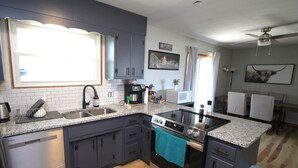 A modern kitchen with granite countertops, stainless steel appliances, and a central island. - The Maine House in State College - 2 miles to PSU via walking path or car! (State College)