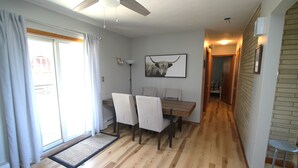 A dining area with a wooden table, four chairs, a ceiling fan, and a framed picture on the wall. - The Maine House in State College - 2 miles to PSU via walking path or car! (State College)
