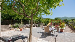 A patio with outdoor furniture, a swing set, and a view of mountains. - Beautiful home in Zavojane (Zavojane)