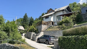 Una casa moderna con una escalera de piedra que lleva a una terraza de madera.