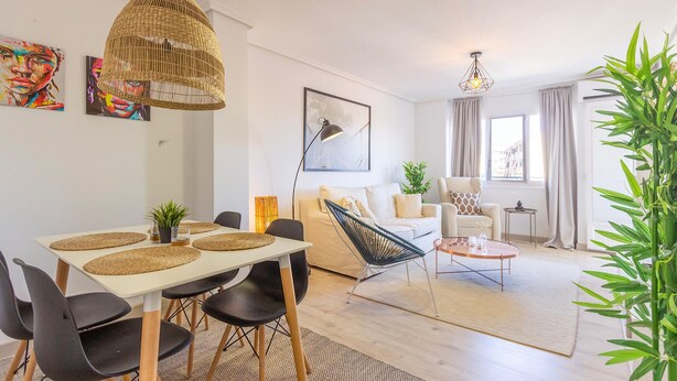 A modern living room with a dining area, featuring a sofa, a coffee table, and a dining table with chairs. - Stunning apartment in El Campello with WiFi (El Campello)