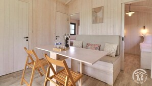 Un intérieur en bois comprenant une table à manger, des chaises, un canapé et un lit.