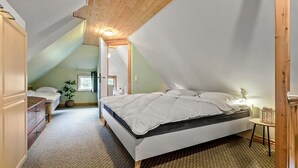 A bedroom with a sloped ceiling, a bed, a bedside table, and a window. - 2 bedroom pet friendly home in Glesborg (Glesborg)