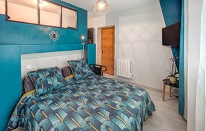 Une chambre à coucher avec un lit, un miroir, une porte en bois, un radiateur et une plante en pot.