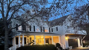 A two-story house with a porch, a garage, and a well-maintained lawn.