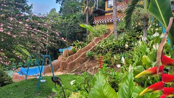 Stroll through the serene garden, surrounded by vibrant flowers and lush greenery, and take a seat in the shaded area.