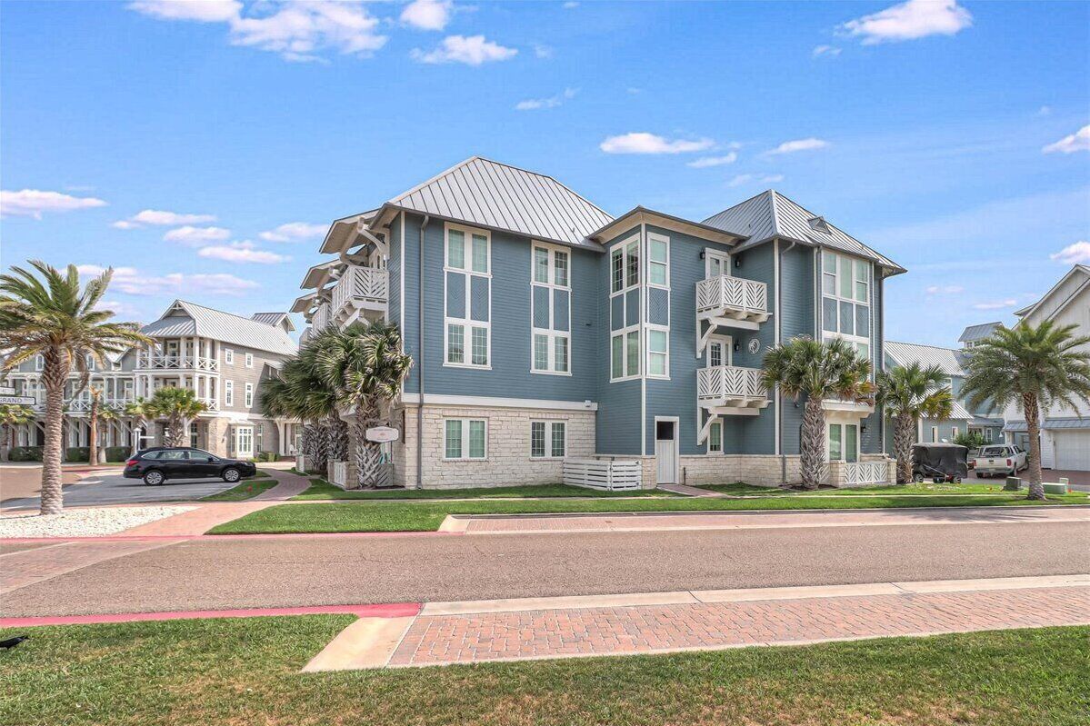 A multi-story residential building with a blue exterior, white trim, and a sloped roof.