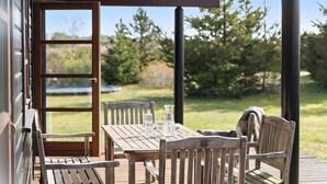 A wooden deck with a table and chairs, a glass of water, and a bottle on the table. - Gorgeous home in Ejstrupholm with WiFi (Ejstrupholm)