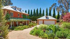 A large house with a garden, a garage, and a covered porch. - Stunning Highlands Manor-Accommodates 2-12 people  (Mittagong)