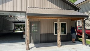 A building with a covered entrance and a garage door. - Fisherman's Retreat! (Burwell)