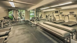 Een fitnessruimte met loopbanden, elliptische trainers en losse gewichten.