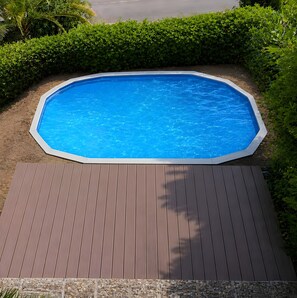 Une piscine octogonale avec une terrasse en bois à l’avant.