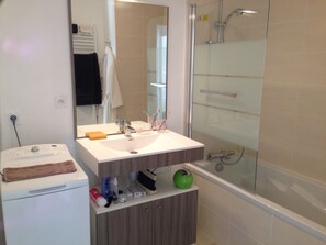 A modern bathroom with a built-in sink, a glass shower enclosure, and a toilet. - L'escale, apartment for 4 guests (Les Sables-d'Olonne)