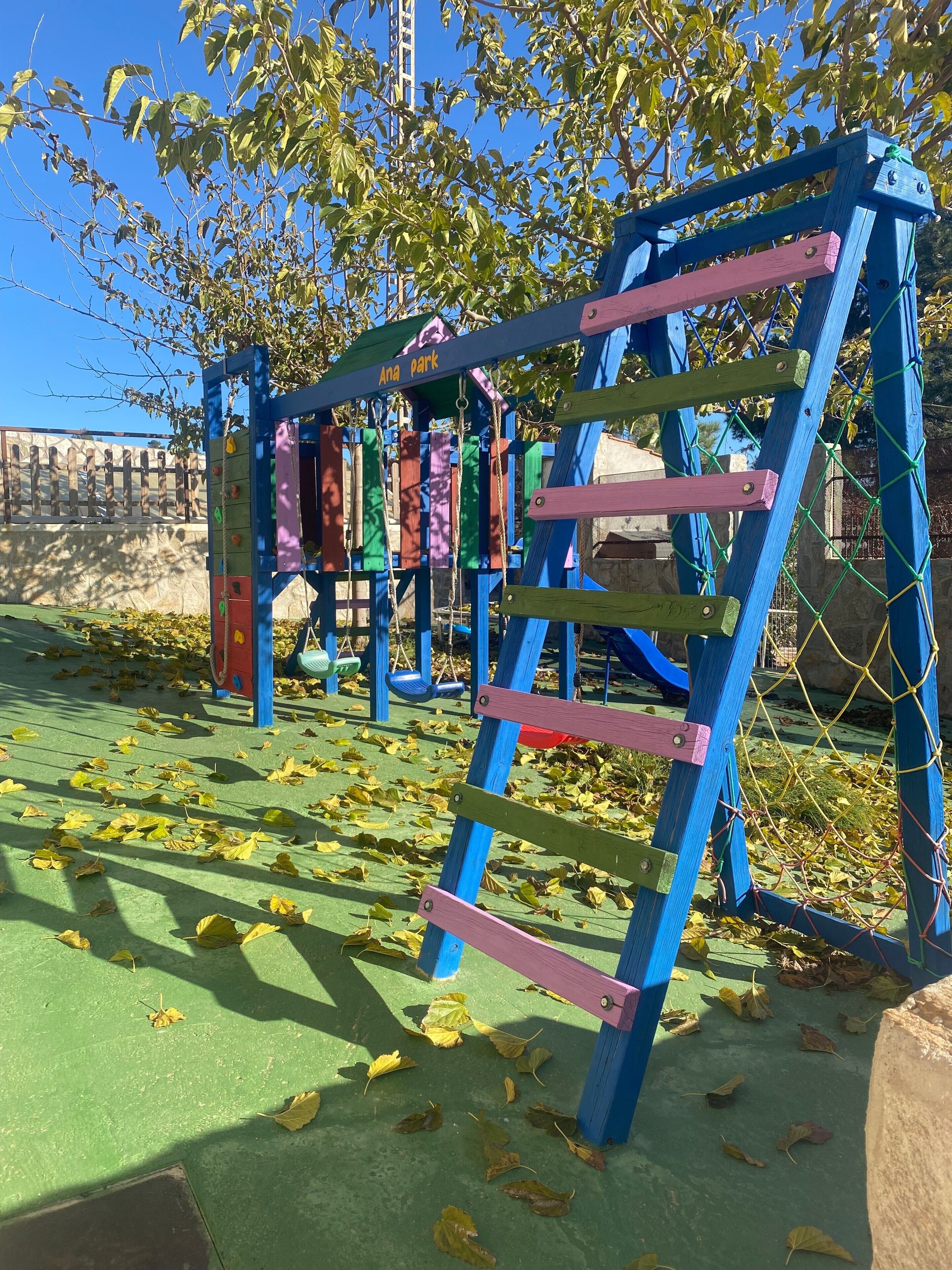 Um parquinho com estrutura de escalada e balanços.