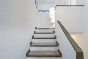 A staircase with a handrail and a door leading to a bathroom.
