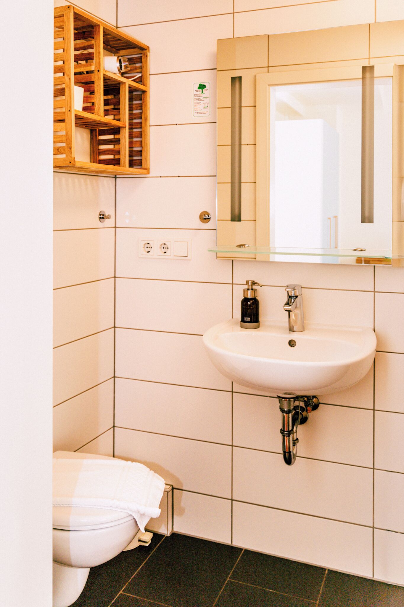 A bathroom with a white sink, a mirror, and a toilet.