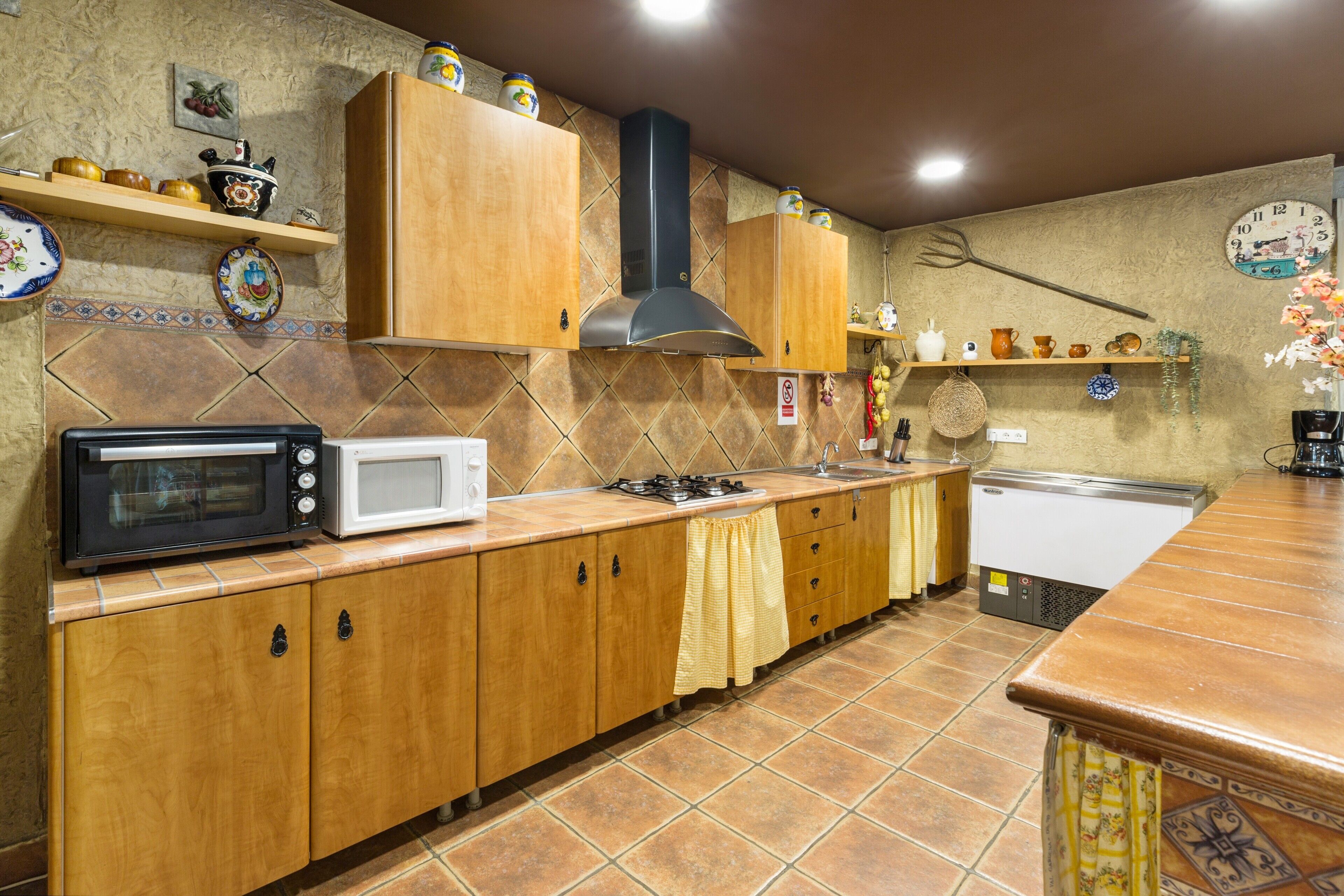 A kitchen with wooden cabinets, a microwave, a stove, and a sink.