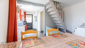 Un comedor con una mesa, sillas y una escalera.
